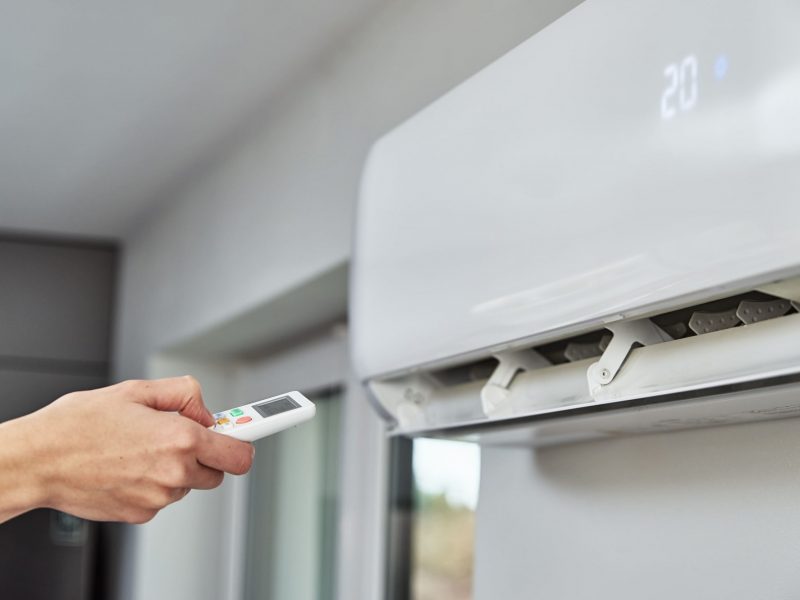 hand-adjusting-temperature-on-air-conditioner-2025-03-13-03-21-48-utc